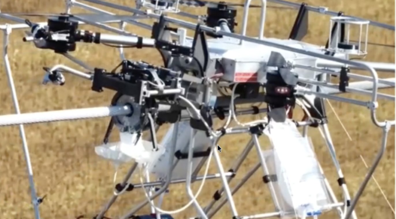 DCAM coating module integrated on a LineDrone UAV above a power-grid conductor during the Hydro-Québec field trial.